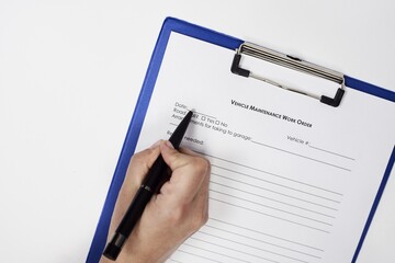 Sticker - Closeup of a person signing a Vehicle Maintenance Work Order Form