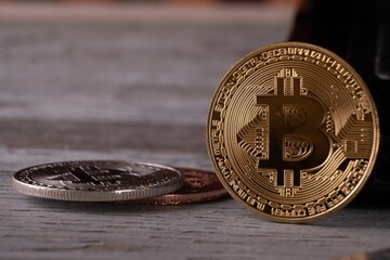 Sticker - Closeup shot of a bitcoin in a wooden surface