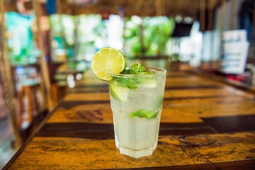 Poster - Closeup shot of a glass of mojito cocktail drink on a table