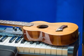 Sticker - Closeup shot of a ukulele on top of an organ with a blurred background