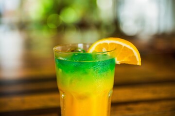 Poster - Closeup shot of a glass of colorful alcoholic cocktail on a table