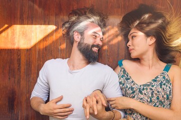 Sticker - Overhead shot of a young couple smiling while laying on the floor - happiness concept