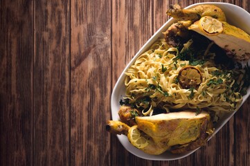 Sticker - Top view of a roasted chicken with Fettucine pasta on a white plate