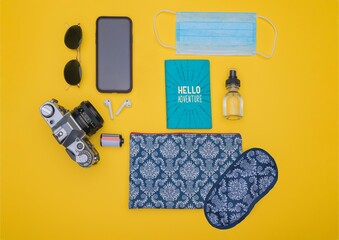 Wall Mural - Sunglasses, smartphone, earpads, camera, film, passport holder, mask, sprayer, pouch, and sleep mask