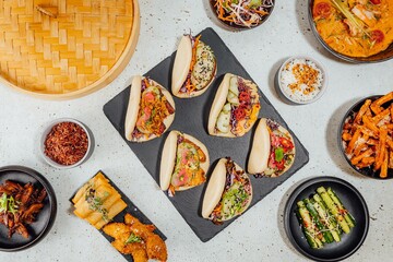 Poster - Top view of bao buns surrounded by different dishes on a white table