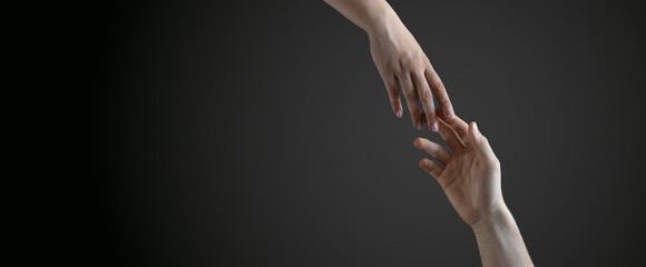 male and female hands reach towards each other