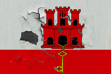 Gibraltar flag close up old, damaged and dirty on wall peeling off paint to see inside surface. Vintage National Concept.