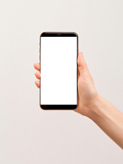 A modern smartphone with large empty screen with copy space in the elegant hand of a girl on a white background