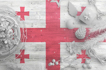 Wall Mural - Georgia flag on wooden table with snow objects. Christmas and new year background, celebration national concept with white decor.