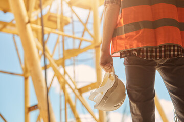 close up of a young worker holding a construction helmet in his hand