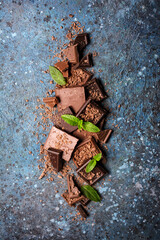 Wall Mural - Pieces of tasty milk and dark chocolate with fresh mint leaves