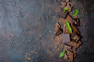 Pieces of tasty milk and dark chocolate with fresh mint leaves