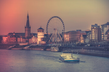 Wall Mural - Dusseldorf, Germany - Evening Sunset View of the Boat on Rhine River and the Old Town of Dusseldorf, Germany