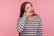 © khosrork - Call me! Portrait of beautiful happy flirtatious woman in striped sweatshirt winking playfully and making telephone hand gesture, imitating phone conversation. studio shot isolated on pink background