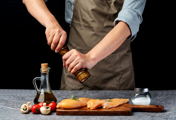 Wall Mural - Chef is grinding pepper to marinate chicken breast