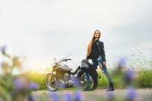 Model Girl Biker Posing Near Her Motorcycle On The Empty Road