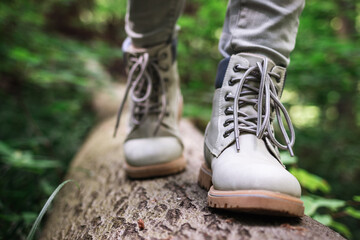 Wall Mural - hiking boot. hiker walking at fallen tree trunk in forest