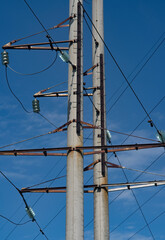 A pillar of power lines against a blue sky.