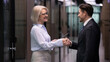 © fizkes - Older businesswoman and businessman shake hands standing in office. Two business partners greeting happy smiling. Senior lady boss handshaking new worker, client or colleague. Partnership handshake