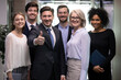 © fizkes - Portrait of successful adult business man with diverse team of happy workers. Senior male leader standing in front of smiling business group. Boss with employee showing thumb up. Leadership, success
