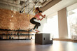 © Svitlana - Sportive young woman jumping using plyo box while having workout at industrial gym