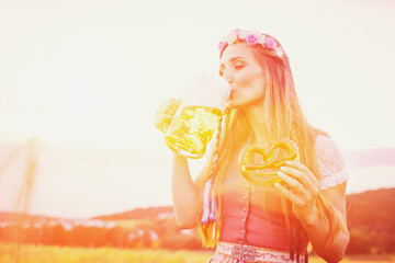 Wall Mural - Bavarian woman with beer and pretzel in beautiful landscape