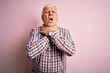 © Krakenimages.com - Senior handsome hoary man wearing casual colorful shirt over isolated pink background shouting suffocate because painful strangle. Health problem. Asphyxiate and suicide concept.