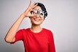 © Krakenimages.com - Young beautiful asian girl wearing optometry glasses standing over isolated white background doing ok gesture with hand smiling, eye looking through fingers with happy face.