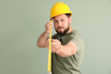 Wall Mural - Male worker with tape measure on color background