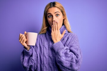 Poster - Young beautiful blonde woman drinking cup of coffee over isolated purple background cover mouth with hand shocked with shame for mistake, expression of fear, scared in silence, secret concept