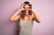 © Krakenimages.com - Young beautiful brunette girl wearing casual striped t-shirt over isolated pink background doing ok gesture like binoculars sticking tongue out, eyes looking through fingers. Crazy expression.