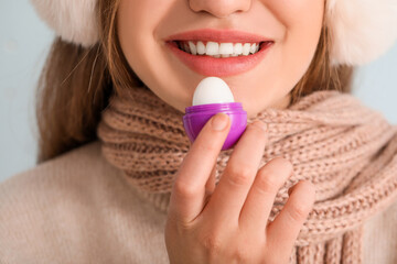 Poster - Beautiful young woman with lip balm, closeup