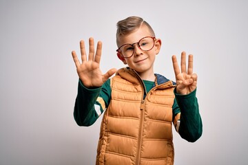 Wall Mural - Young little caucasian kid with blue eyes wearing winter coat and smart glasses showing and pointing up with fingers number eight while smiling confident and happy.