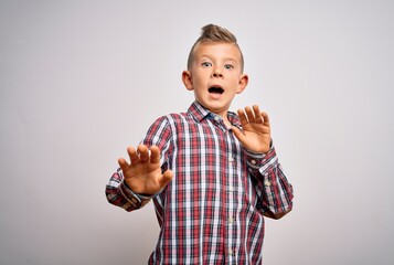 Young little caucasian kid with blue eyes wearing elegant shirt standing over isolated background afraid and terrified with fear expression stop gesture with hands, shouting in shock. Panic concept.