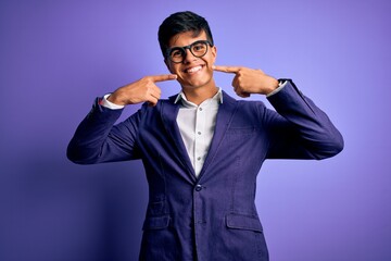 Sticker - Young handsome business man wearing jacket and glasses over isolated purple background smiling cheerful showing and pointing with fingers teeth and mouth. Dental health concept.