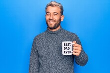 Handsome Blond Man Drinking Cup Of Coffee With Best Dad Ever Message Over Blue Background Looking Positive And Happy Standing And Smiling With A Confident Smile Showing Teeth