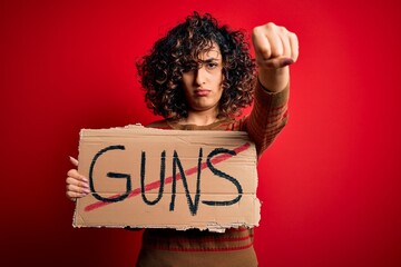 Poster - Young beautiful arab woman asking for peace holding banner with prohibited guns message annoyed and frustrated shouting with anger, crazy and yelling with raised hand, anger concept