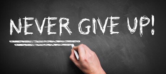Wall Mural - hand is writing NEVER GIVE UP on a chalkboard