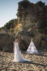 Wall Mural - Brunette caucasian bride posing at the beach in front of a white tent