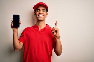 Wall Mural - Young handsome african american delivery man holding smartphone showing screen app surprised with an idea or question pointing finger with happy face, number one