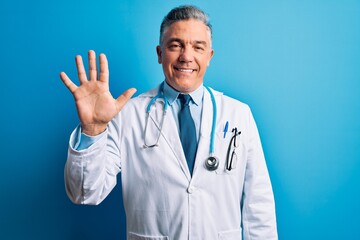 Canvas Print - Middle age handsome grey-haired doctor man wearing coat and blue stethoscope showing and pointing up with fingers number five while smiling confident and happy.