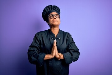 Poster - Young african american chef girl wearing cooker uniform and hat over purple background begging and praying with hands together with hope expression on face very emotional and worried. Begging.