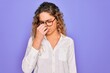 © Krakenimages.com - Young beautiful woman with blue eyes wearing casual shirt and glasses over purple background tired rubbing nose and eyes feeling fatigue and headache. Stress and frustration concept.