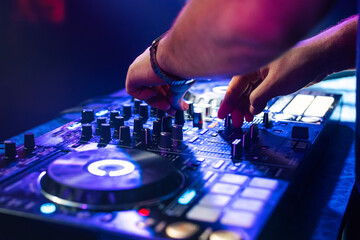 Wall Mural - DJ hands mix music on a mixing Board in a nightclub