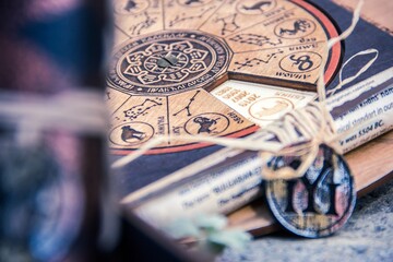 shallow focus closeup shot of an astrological calendar with a necklace