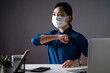 © chajamp - Asian woman in blue shirt wearing protective face mask confident put her fist on a left chest showing a trust and at office. isolated on background.