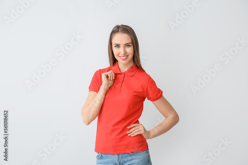 Fotomural Beautiful young woman in stylish polo shirt on light background