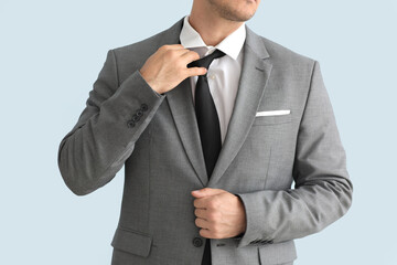 Wall Mural - Young businessman in stylish suit on color background