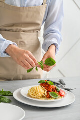 Woman cooking tasty pasta bolognese in kitchen, closeup