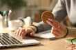 © PheelingsMedia - Student hands holding cookie at night studying